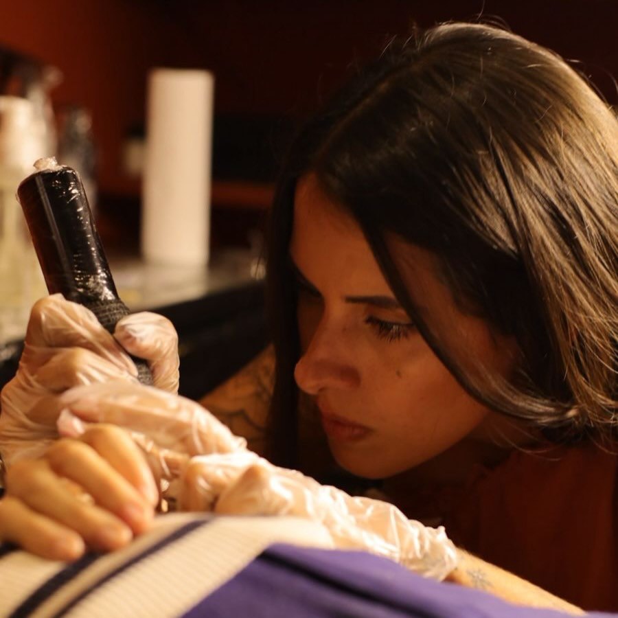 Ana Terra realizando a tatuagem