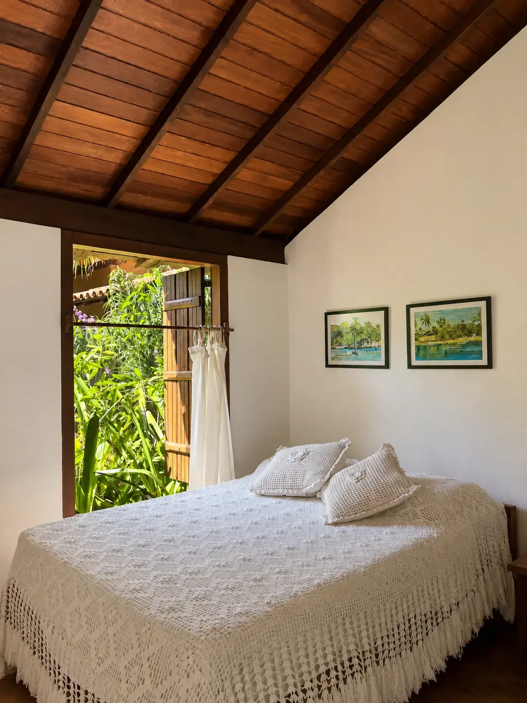 Cama principal do Bangalô 7 com vista para a vegetação externa