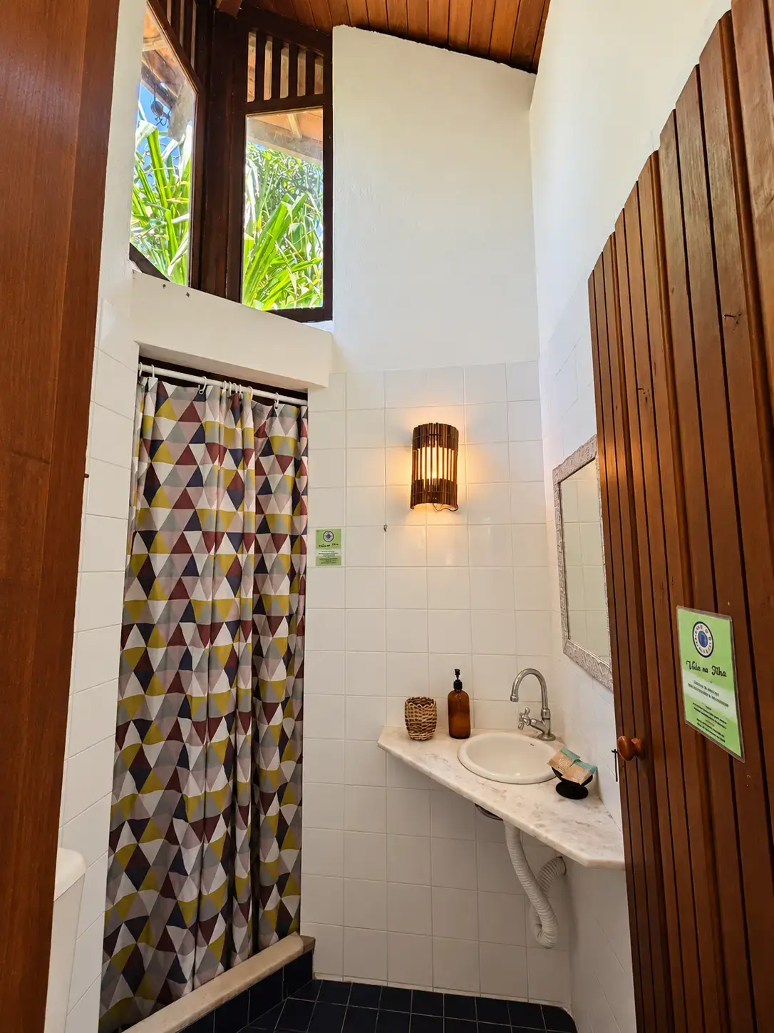 Banheiro do Bangalô 7 com luz natural e porta voltada para a área externa